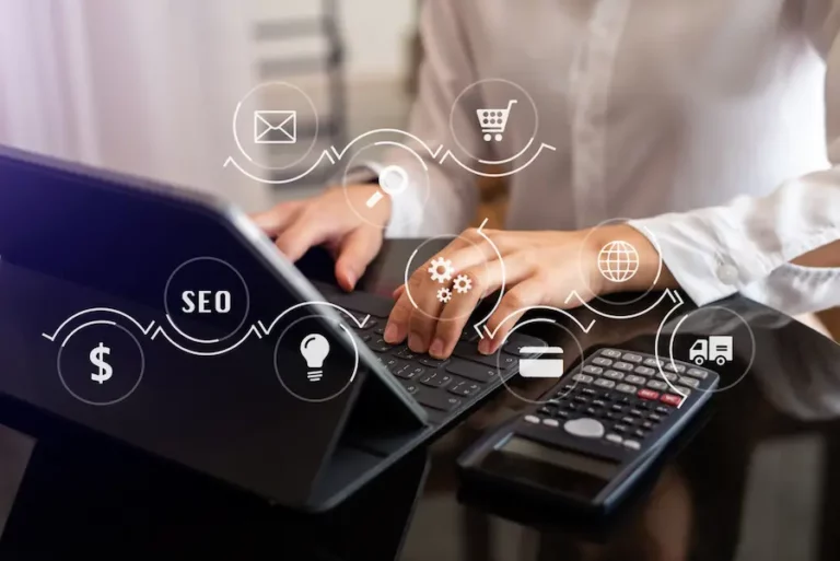 Pessoa Digitando Em Um Teclado De Laptop Com Ícones Representando Seo, Comércio Eletrônico, Marketing Digital E Outras Estratégias Ao Redor. A Imagem Ilustra O Conceito De Otimização De Seo Para E-Commerce, Tema Abordado No Blog.